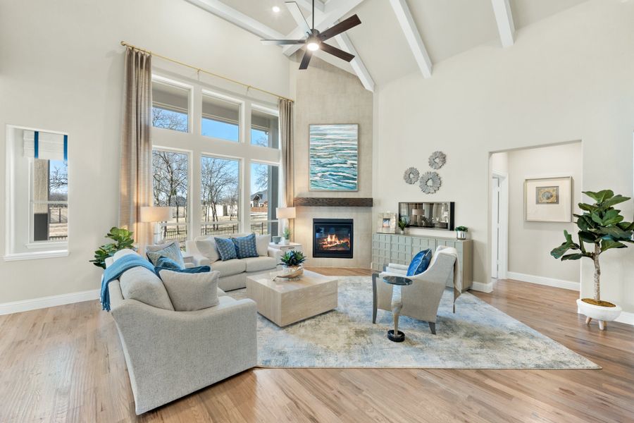Living room with vaulted beamed ceiling, fireplace, hardwood floors, and large windows Living room with vaulted beamed ceiling, fireplace, hardwood floors, and large windows