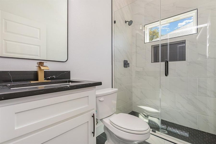 Full bathroom with a shower stall, vanity, and toilet