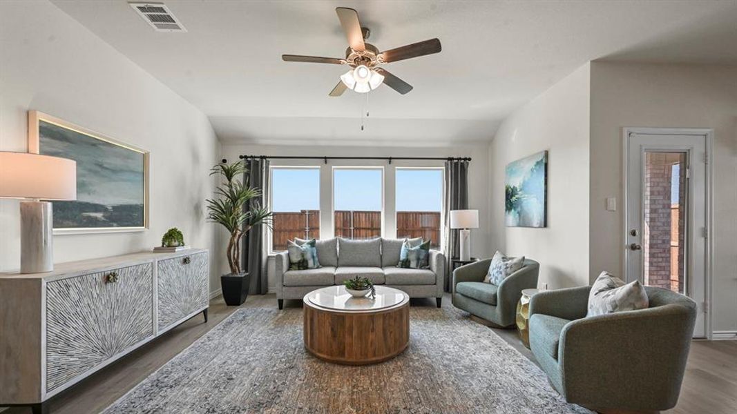 Living area with wood finished floors, ceiling fan, and vaulted ceiling