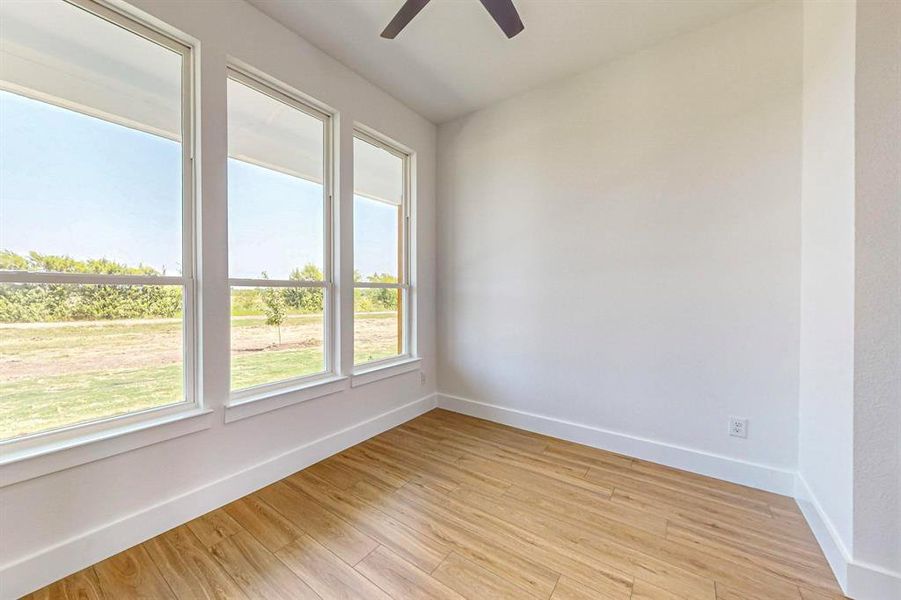 Empty room featuring light wood-type flooring and ceiling fan