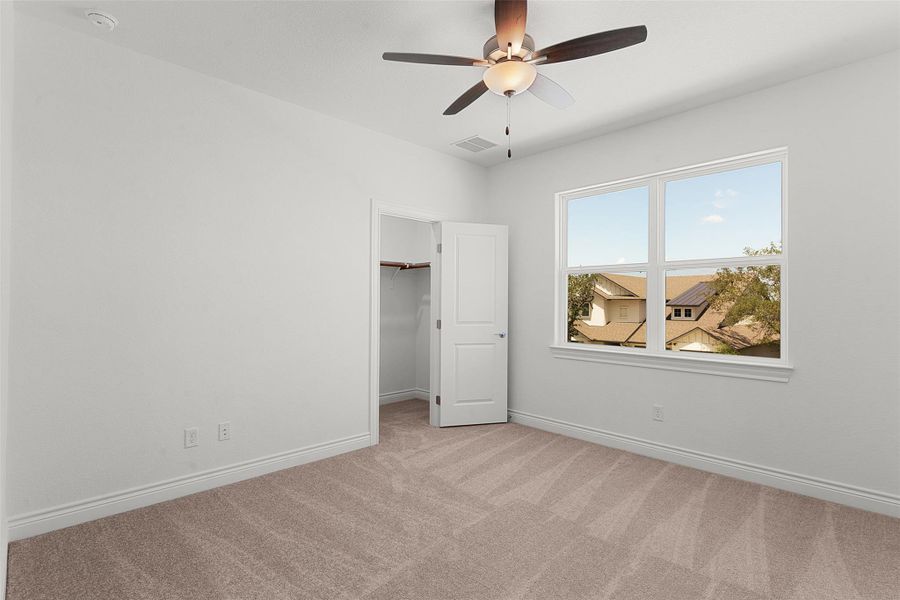 Bedroom featuring carpet flooring, white walls, and a ceiling fan with integrated lighting