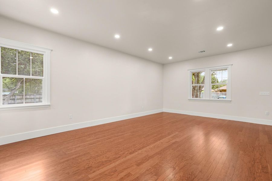 Hardwood floors and ample recessed lighting complete this versatile, well-lit living space. Hardwood floors and ample recessed lighting complete this versatile, well-lit living space.