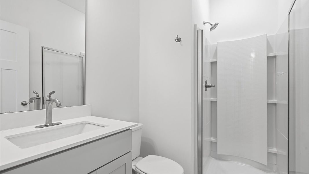 Refined hall bath with elevated finishes and a highly functional layout at the Pinebrook community