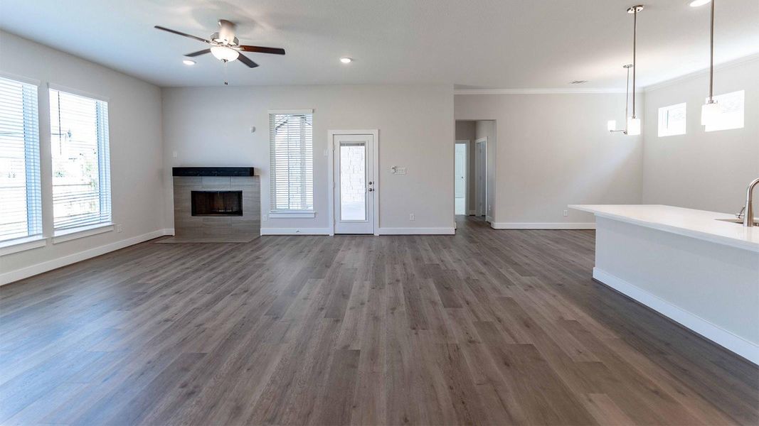 Unfurnished living room with a tile fireplace, ceiling fan, recessed lighting, and dark wood-style floors Unfurnished living room with a tile fireplace, ceiling fan, recessed lighting, and dark wood-style floors