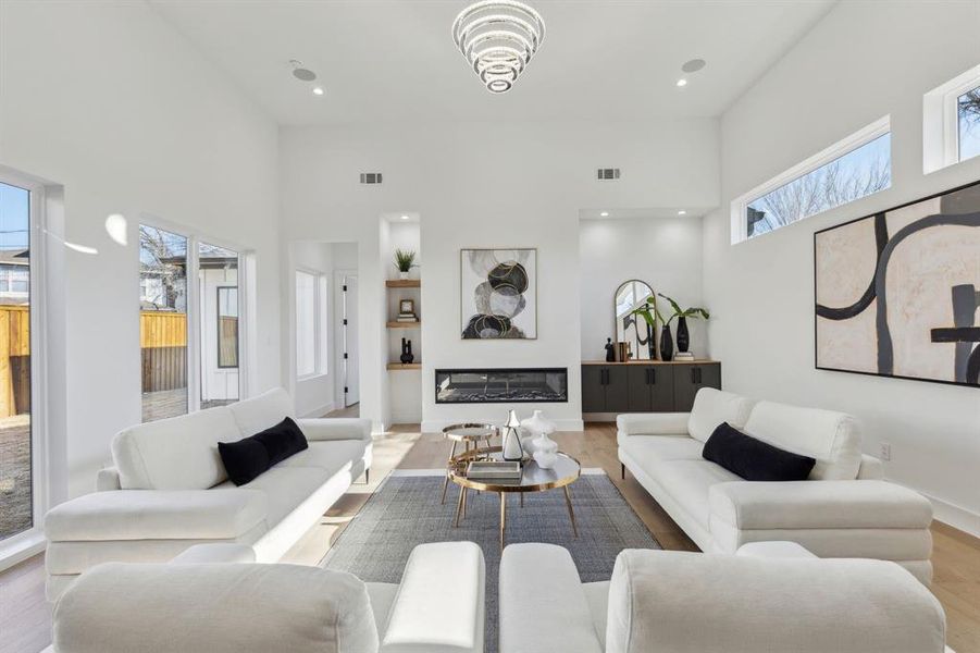 Living room featuring a towering ceiling and light hardwood / wood-style floors