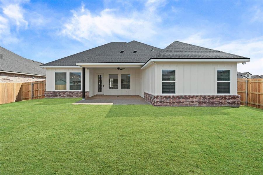 Rear view of property featuring roof with shingles, a fenced backyard, brick siding, and ceiling fan