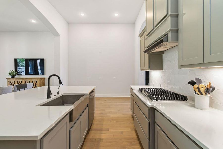 A well-lit kitchen with sleek countertops and light hardwood flooring, perfect for culinary endeavors.
