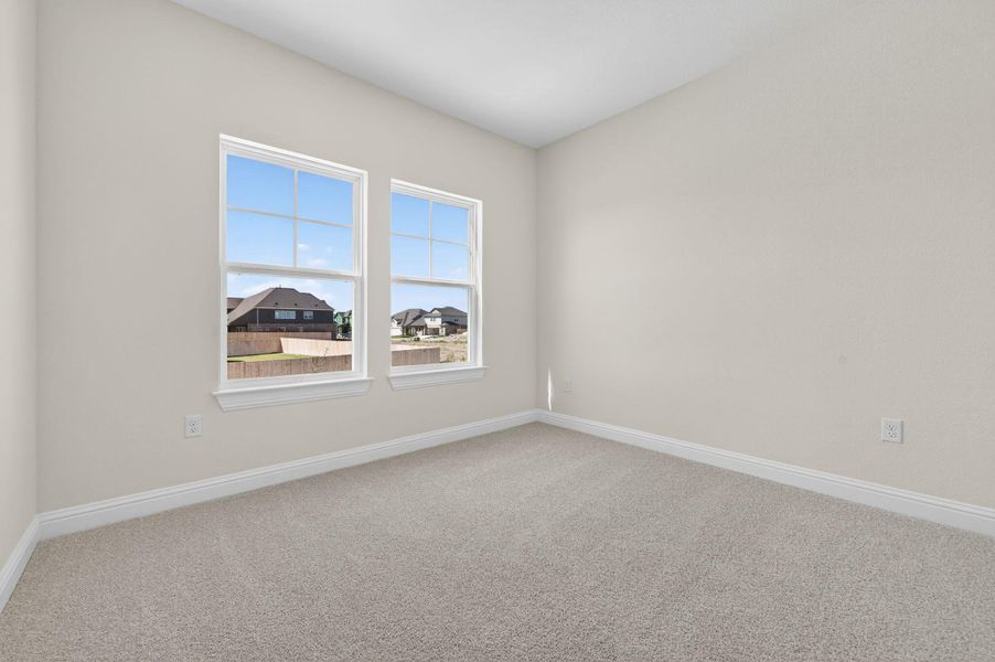 Empty room featuring light colored carpet and baseboards