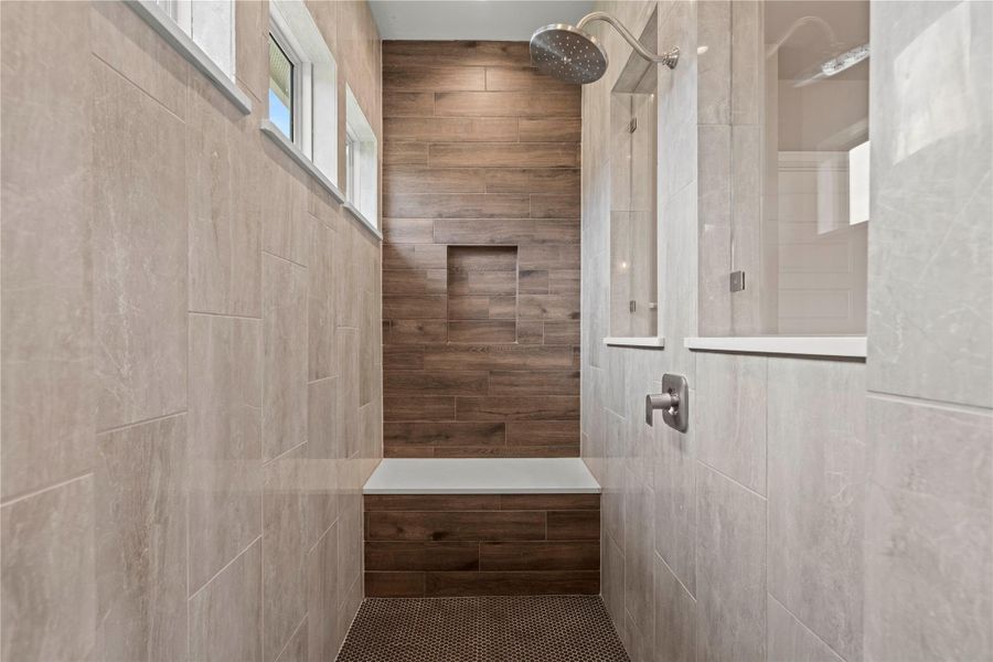 A rain shower head and built-in bench create a rejuvenating experience in this modern tiled bathroom. A rain shower head and built-in bench create a rejuvenating experience in this modern tiled bathroom.
