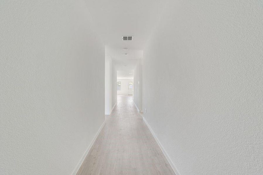 Hallway featuring light wood-style flooring and baseboards