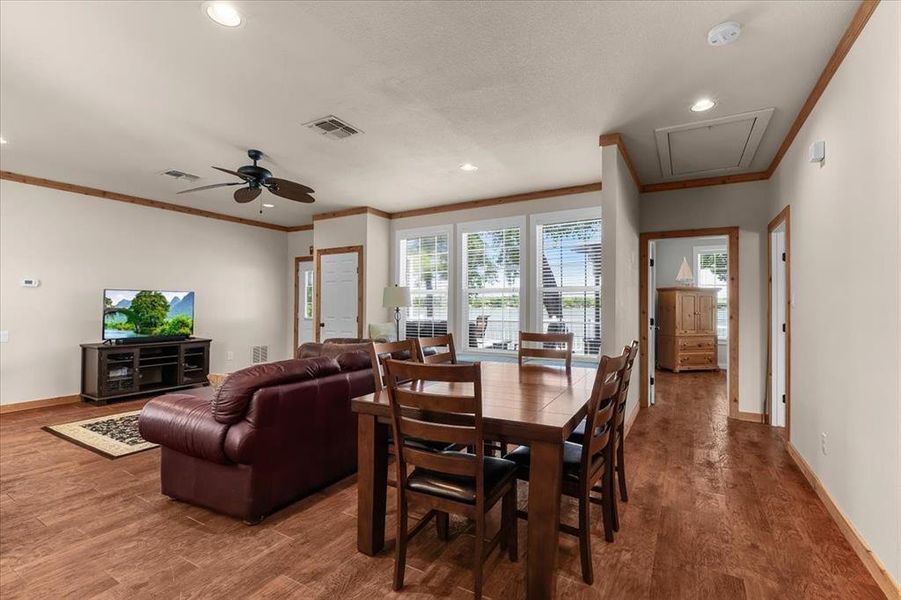 Dining space with wood finished floors, plenty of natural light, recessed lighting, ornamental molding, and a ceiling fan