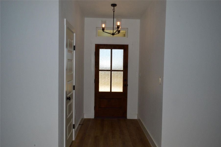 Doorway to outside with wood finished floors and a chandelier Doorway to outside with wood finished floors and a chandelier