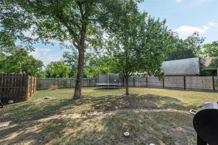 Fenced backyard featuring a trampoline Fenced backyard featuring a trampoline
