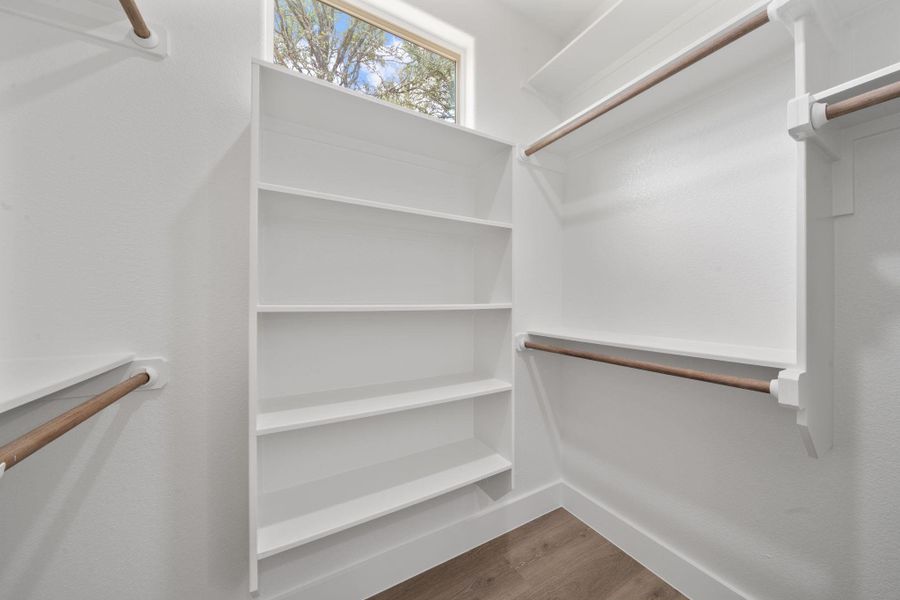 Walk-in closet with ample built-in shelving and hanging rods