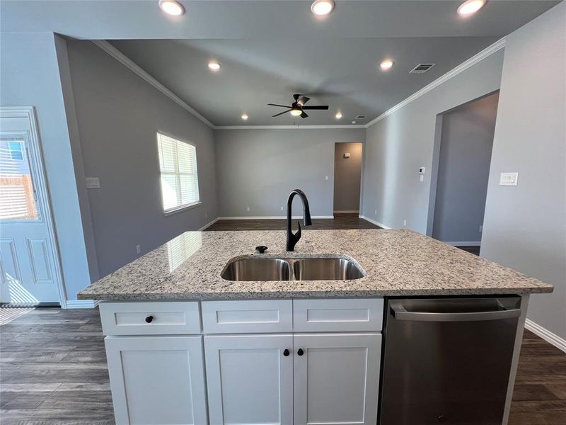 Kitchen with sink, white cabinets, stainless steel dishwasher, and plenty of natural light