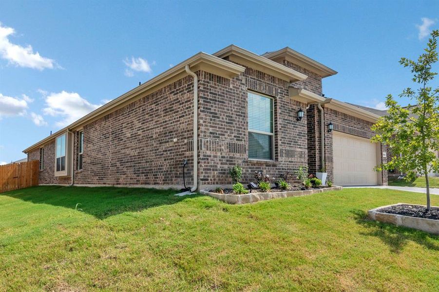 View of side of property with an attached garage and brick siding