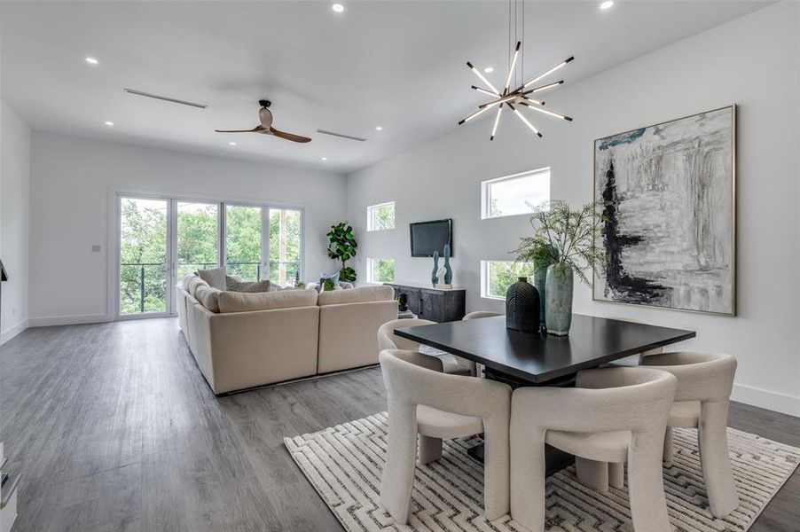 Dining space featuring light wood-type flooring and ceiling fan with notable chandelier