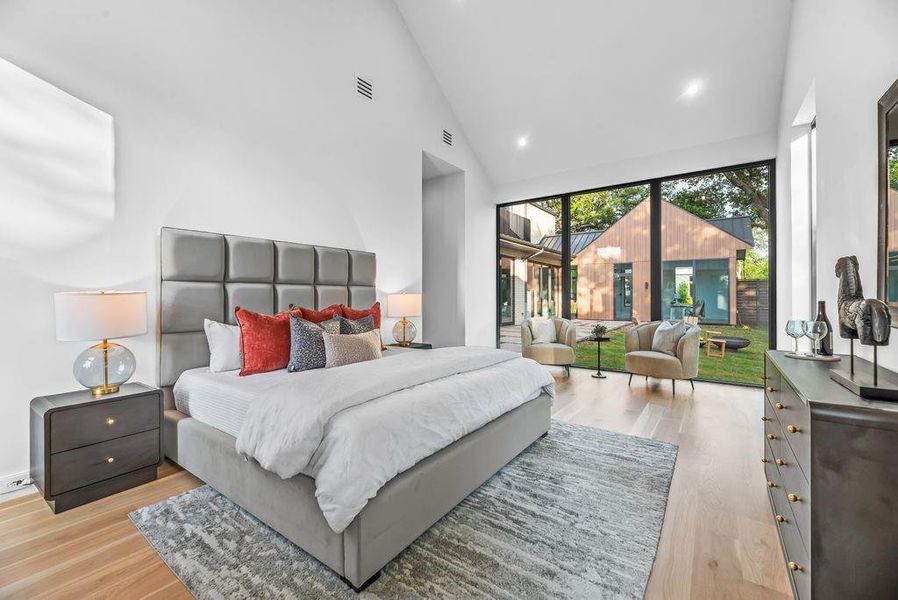 The primary suite offers a light-filled retreat with vaulted ceilings and expansive glass that draws in the natural surroundings, creating a calm and restorative atmosphere.