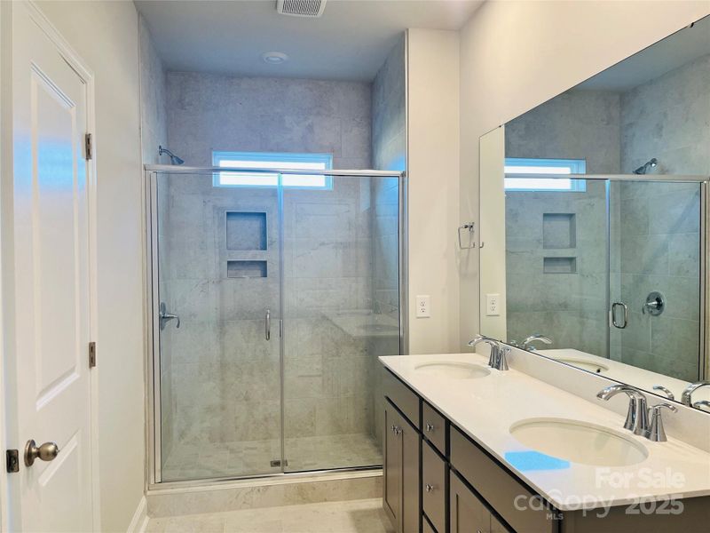 Primary Bath with tiled shower and double vanity