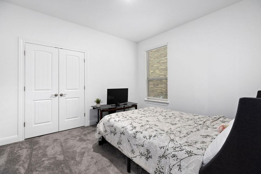 A well-lit bedroom features plush carpeting and a convenient double-door closet.