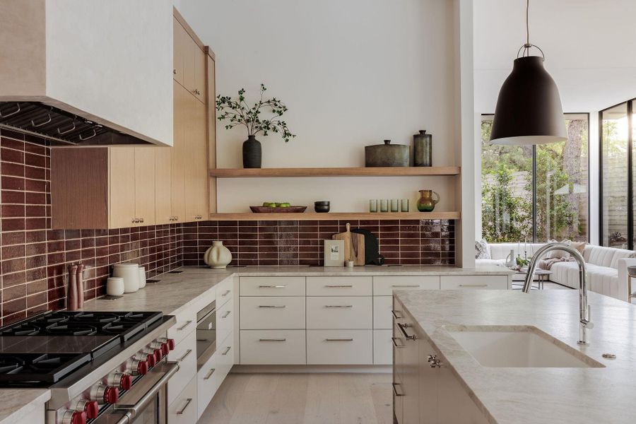 Kitchen with stainless steel range, open shelves, ventilation hood, and decorative backsplash Kitchen with stainless steel range, open shelves, ventilation hood, and decorative backsplash