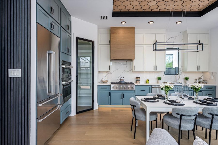 The kitchen/dining area features bespoke chandeliers and a tray ceiling with wood inlays, offering a truly refined dining experience The kitchen/dining area features bespoke chandeliers and a tray ceiling with wood inlays, offering a truly refined dining experience