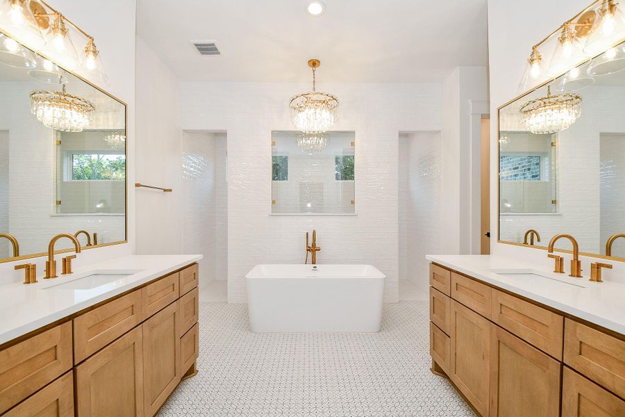 Step into luxury in the spa-inspired primary bath, complete with dual vanities, designer lighting, and stylish tile work. The oversized walk-in shower features a frameless glass enclosure and dual shower heads, while a freestanding soaking tub offers the ultimate relaxation. Custom cabinetry and sleek finishes complete the space. Step into luxury in the spa-inspired primary bath, complete with dual vanities, designer lighting, and stylish tile work. The oversized walk-in shower features a frameless glass enclosure and dual shower heads, while a freestanding soaking tub offers the ultimate relaxation. Custom cabinetry and sleek finishes complete the space.