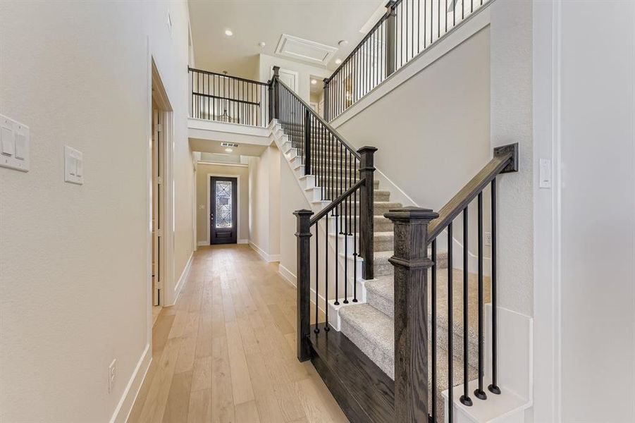 Foyer featuring light wood-type flooring, a high ceiling, and stairway