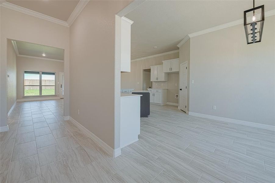Kitchen featuring white cabinets, crown molding, light countertops, open floor plan, and wood tiled floors