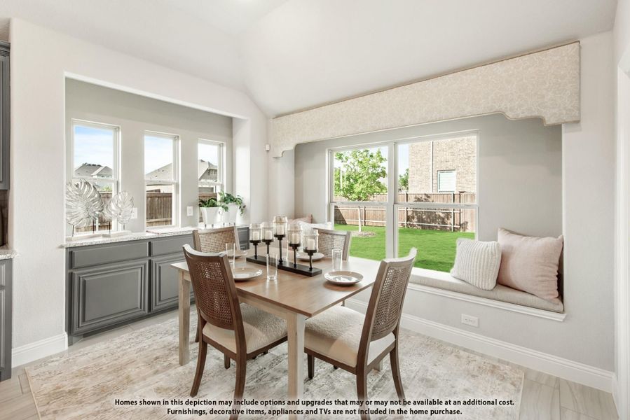 Dining area with wood table, built-in window seat, vaulted ceiling, and large windows overlooking backyard