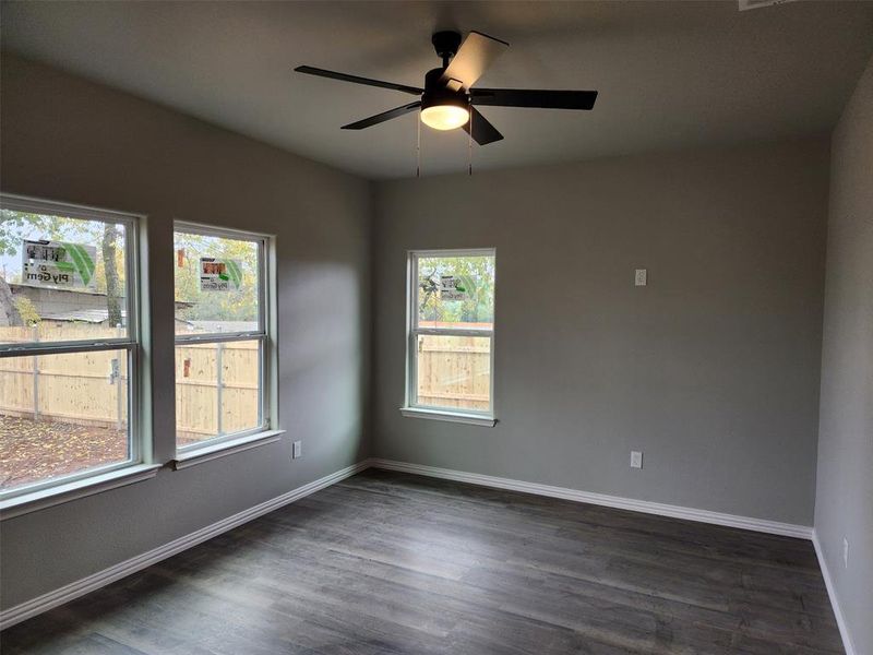 Spare room with dark hardwood / wood-style flooring and a wealth of natural light