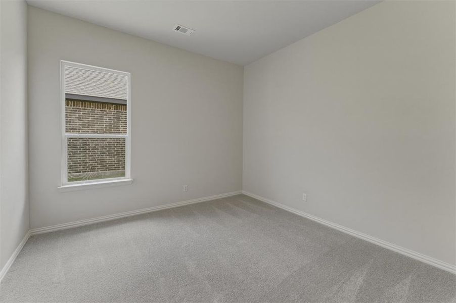 Light gray carpeted room with neutral painted walls, white trim, and a double-hung window Light gray carpeted room with neutral painted walls, white trim, and a double-hung window