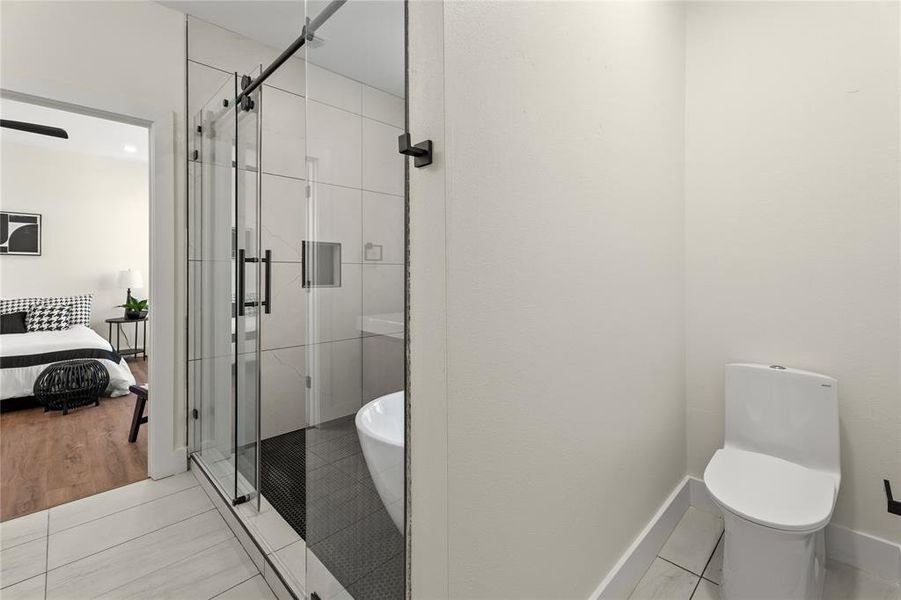 Ensuite bathroom with a stall shower, light tile patterned floors, and a freestanding bath