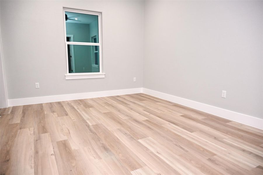 Unfurnished room featuring light wood finished floors and baseboards
