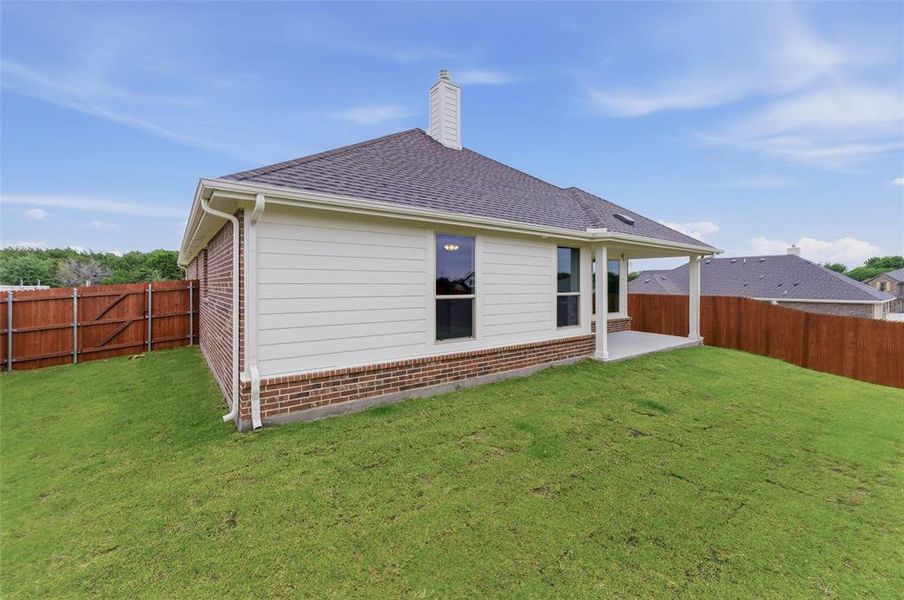 Expansive green lawn with a newly installed wooden privacy fence