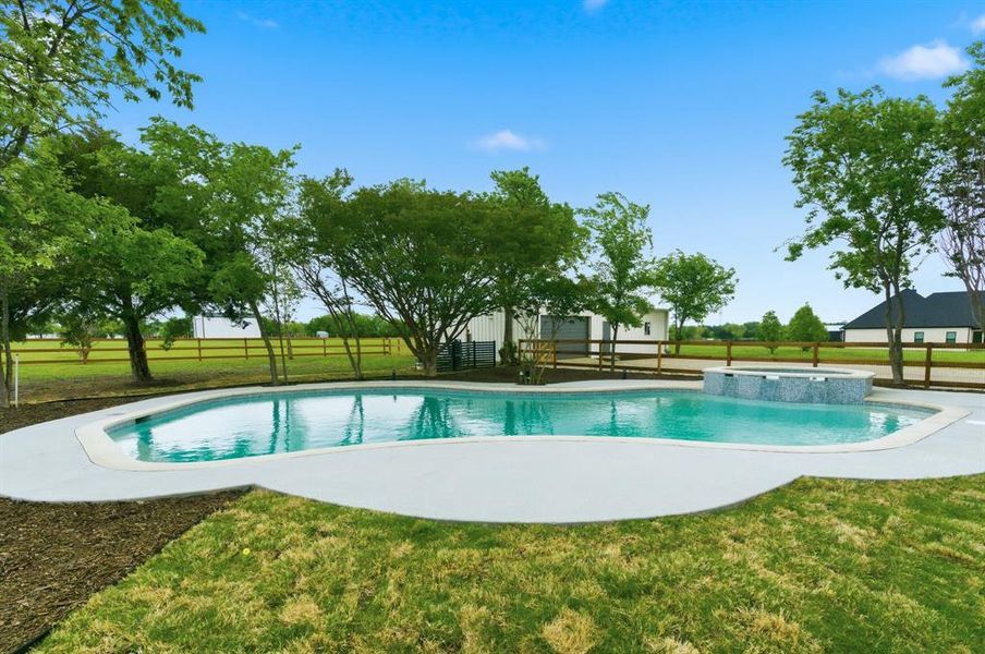The property features a swimming pool with an integrated spa, surrounded by a concrete patio The property features a swimming pool with an integrated spa, surrounded by a concrete patio