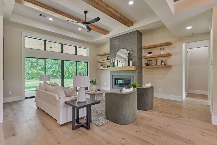 Custom beams, a shiplap fireplace wall with floating wood shelves, and walls of glass sliders bringing in serene backyard views — this living room was designed to be the heart of the home, with plenty of room to gather. Custom beams, a shiplap fireplace wall with floating wood shelves, and walls of glass sliders bringing in serene backyard views — this living room was designed to be the heart of the home, with plenty of room to gather.