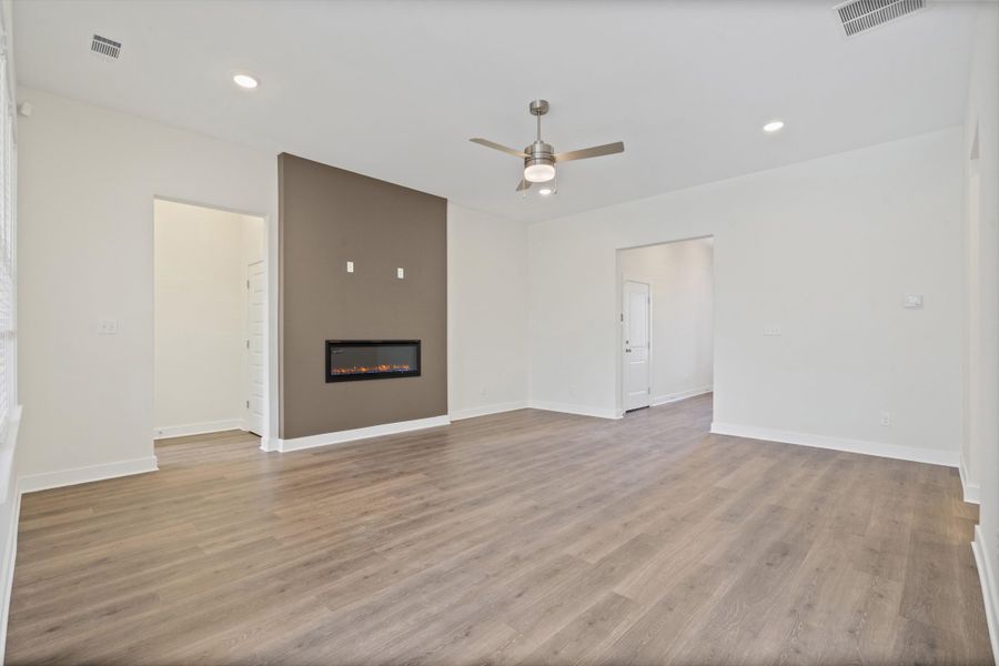 Unfurnished living room with recessed lighting, ceiling fan, light wood-style flooring, and a glass covered fireplace