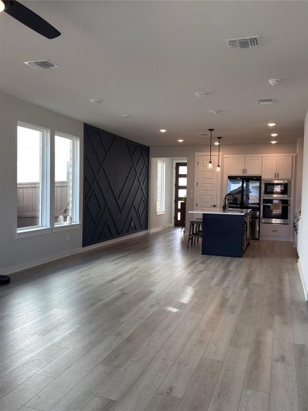 Open-concept living space featuring wood-finish flooring and recessed lighting
