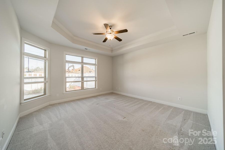 Primary bedroom with trey ceilings