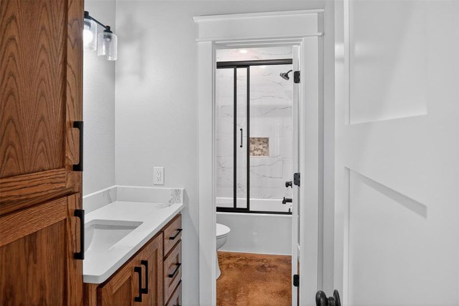 Full Bathroom featuring a wood-finish vanity with a built-in sink and solid surface countertop Full Bathroom featuring a wood-finish vanity with a built-in sink and solid surface countertop