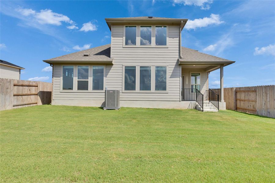 Rear view of house with a shingled roof and a fenced backyard