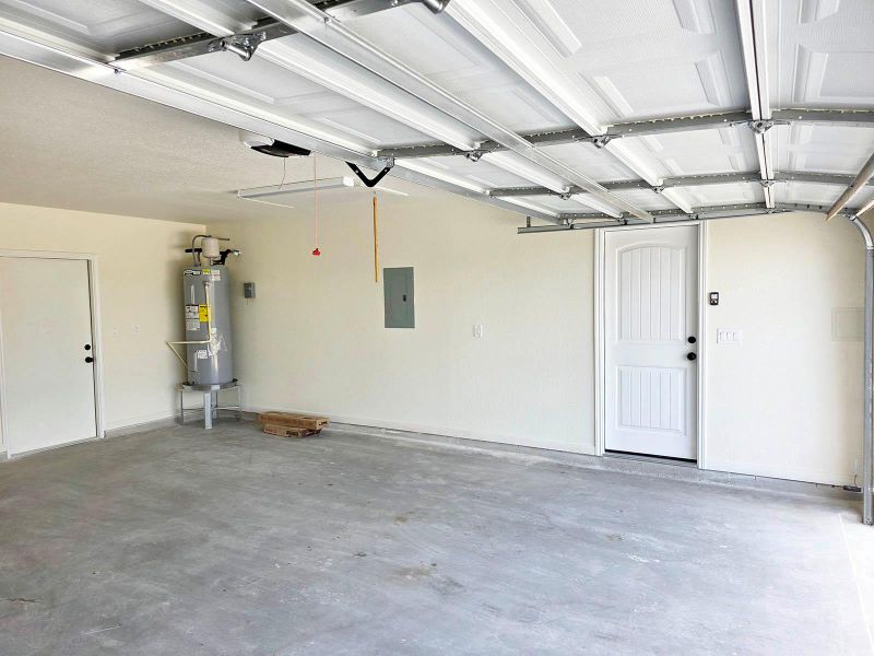 Garage featuring electric panel and water heater
