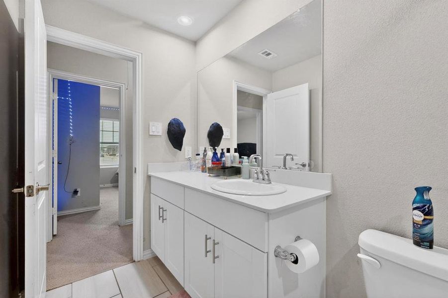 Half bath featuring vanity and light carpet Half bath featuring vanity and light carpet