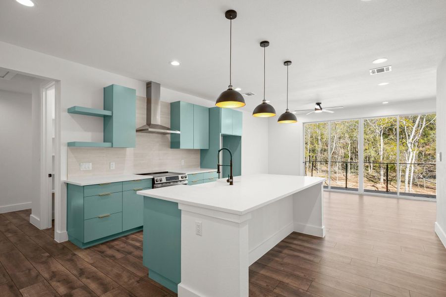 Kitchen featuring open shelves, tasteful backsplash, wall chimney range hood, recessed lighting, and hanging light fixtures