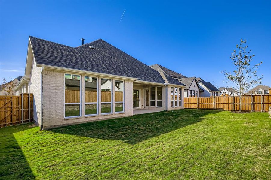 Rear view of property with a patio, brick siding, a fenced backyard, and roof with shingles Rear view of property with a patio, brick siding, a fenced backyard, and roof with shingles