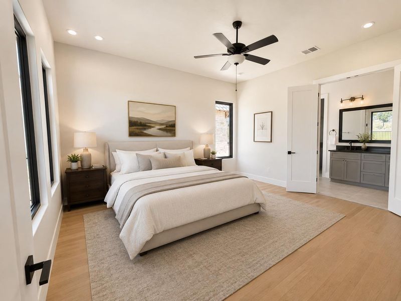 An airy primary bedroom suite features rich hardwood flooring and a seamlessly connected, well-appointed bathroom.