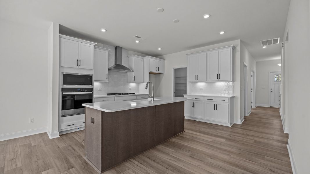 Fairfield design gourmet kitchen with 42" cabinets, wall oven & microwave, vented hood, and large island. DRB Homes. York, SC