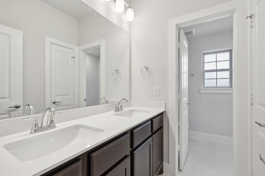 Bathroom featuring tile patterned flooring and double sink vanity