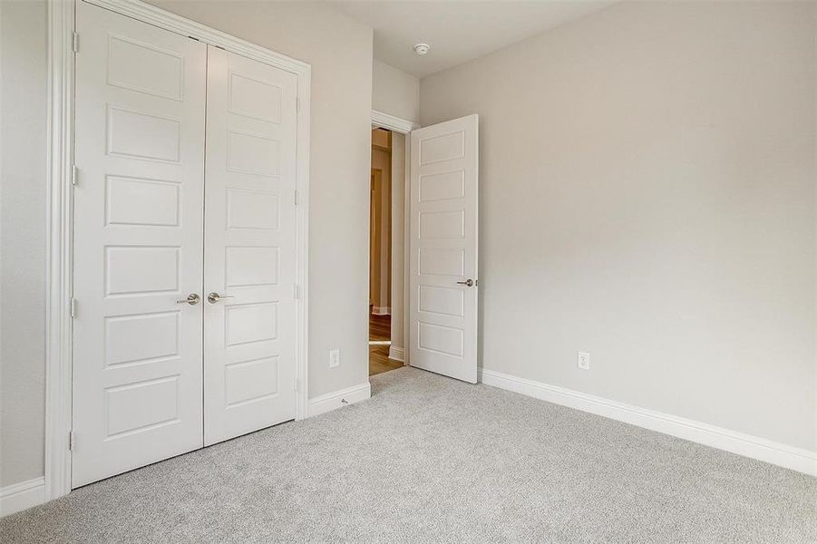 Unfurnished bedroom with a closet and light colored carpet